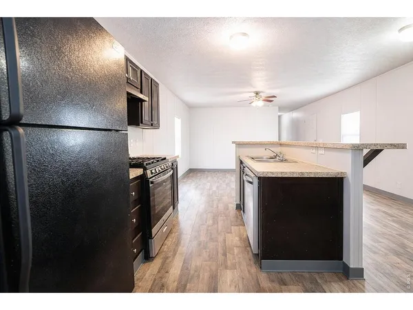 a kitchen with stainless steel appliances granite countertop a refrigerator a stove and a microwave