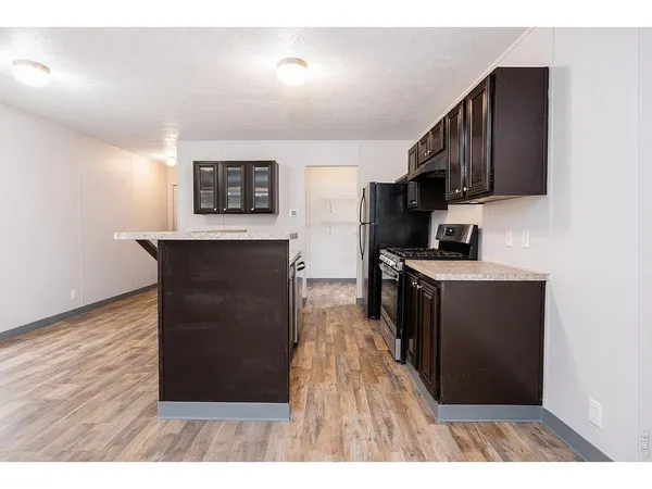 a kitchen with a refrigerator and a stove top oven