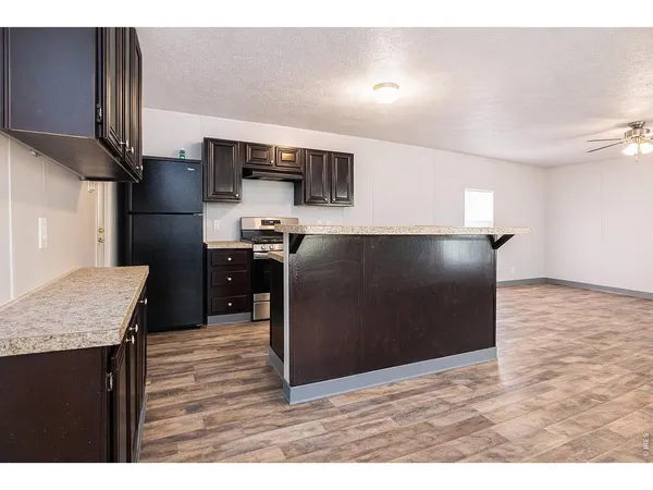 a kitchen with stainless steel appliances granite countertop a refrigerator a sink and a stove
