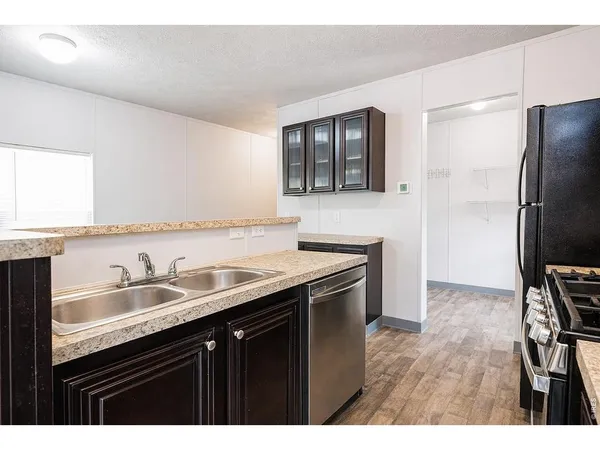 a kitchen with a sink refrigerator and cabinets