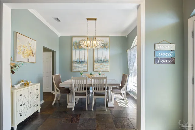 a dining room with wooden floor a chandelier a wooden table and chairs