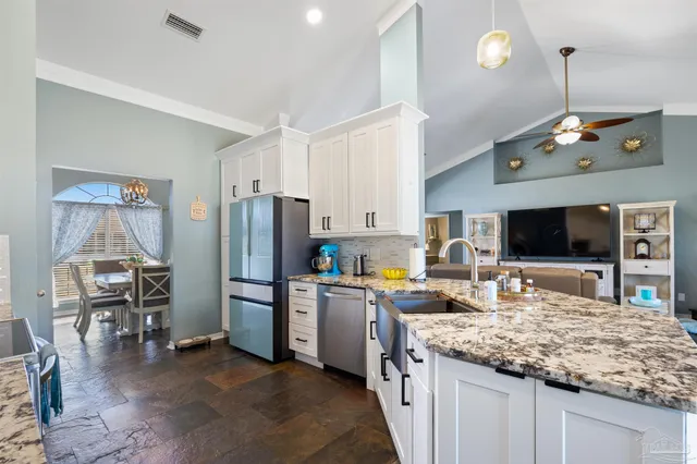 a kitchen with stainless steel appliances granite countertop a kitchen island a stove a table and chairs