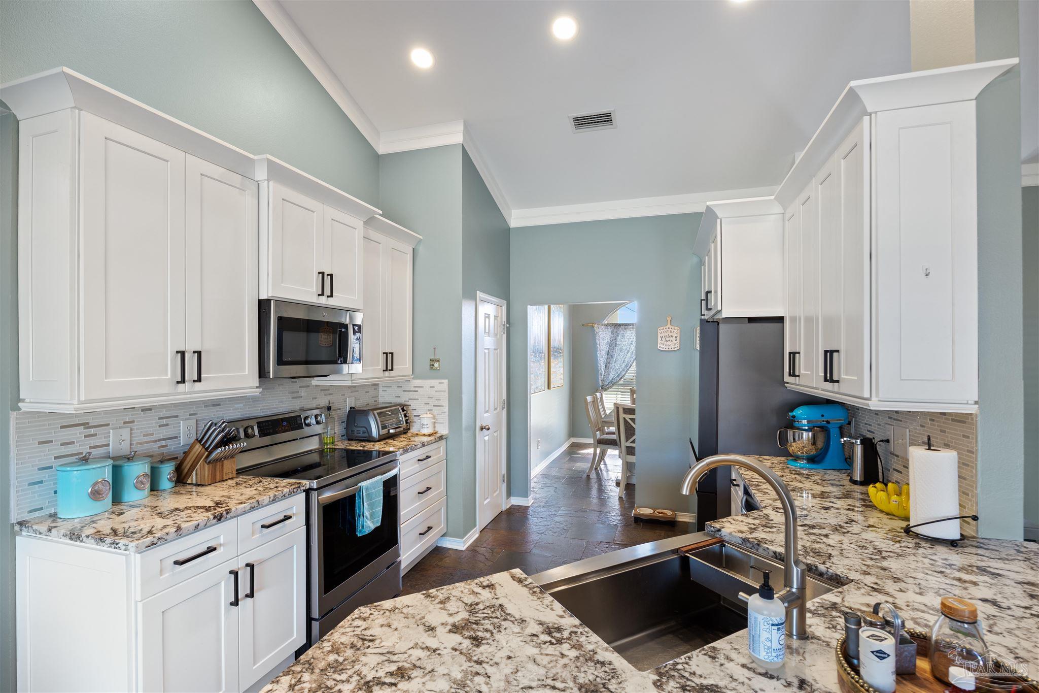 420 Collinwood Loop Foley, AL 36535 - Photo 18 of 63 a kitchen with stainless steel appliances granite countertop a stove refrigerator sink and cabinets