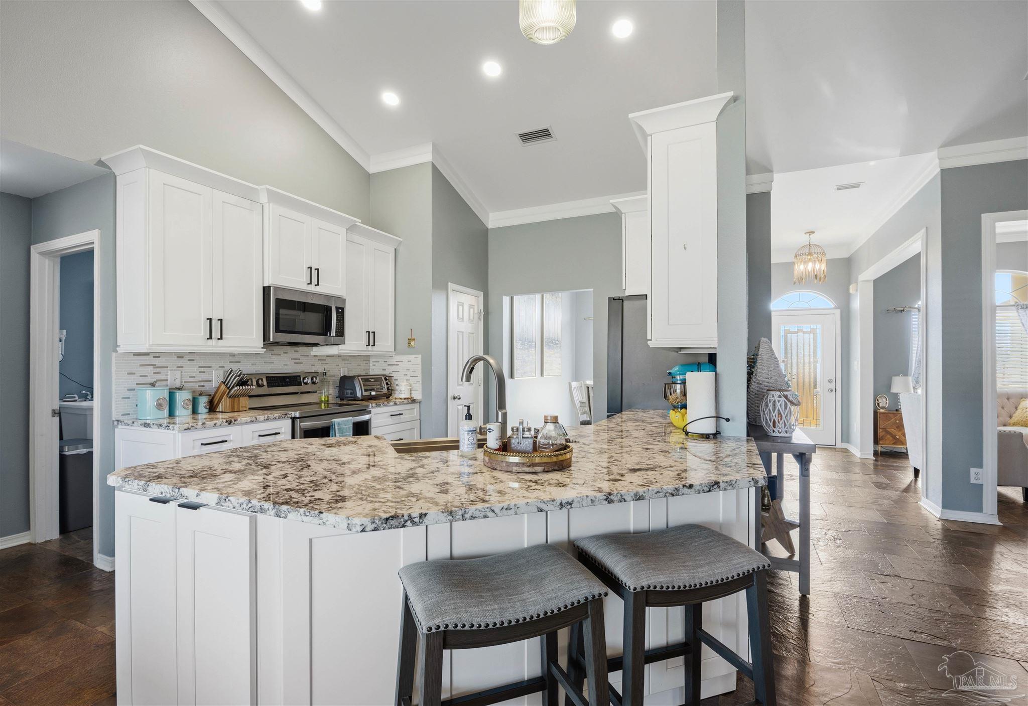 420 Collinwood Loop Foley, AL 36535 - Photo 19 of 63 a kitchen with stainless steel appliances granite countertop a kitchen island a stove a table and chairs