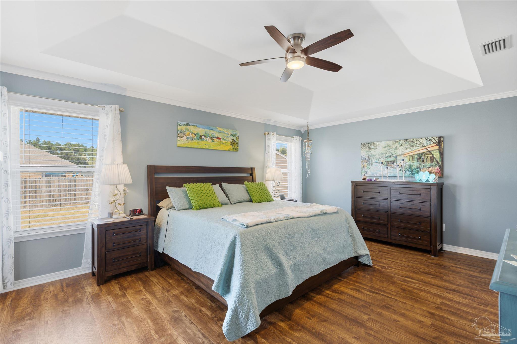 420 Collinwood Loop Foley, AL 36535 - Photo 22 of 63 a bedroom with a bed a dresser and wooden floor