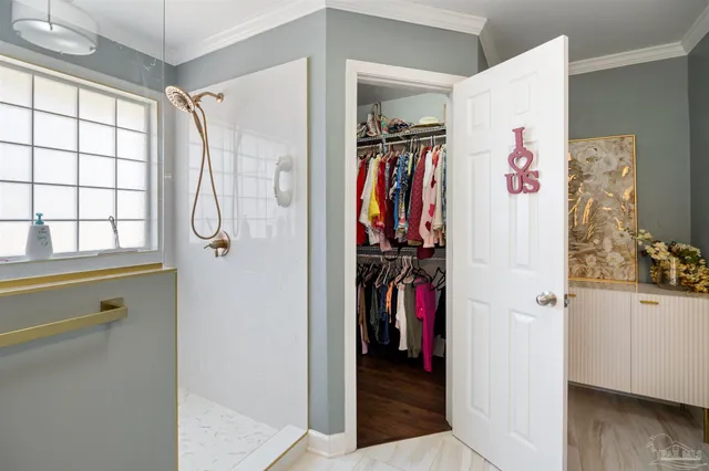 a view of walk in closet with clothes