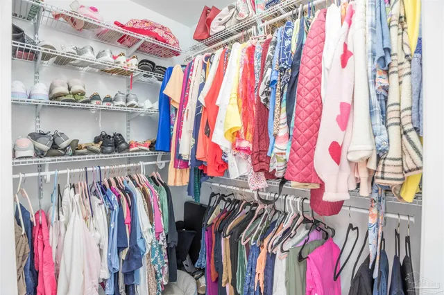 a view of walk in closet with clothes