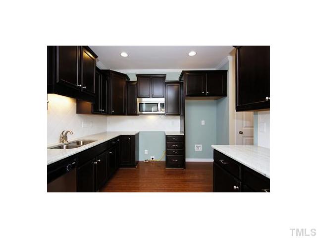 1241 Silver Beach Way Raleigh, NC 27606 - Photo 6 of 20 a kitchen with stainless steel appliances a sink cabinets and a wooden floor