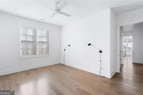 an empty room with wooden floor and windows