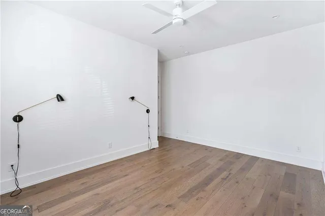 an empty room with wooden floor and door