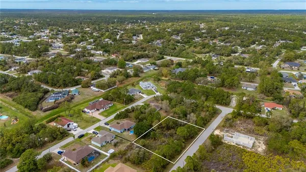 an aerial view of residential houses with outdoor space and trees
