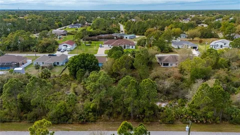 an aerial view of residential houses with outdoor space and trees