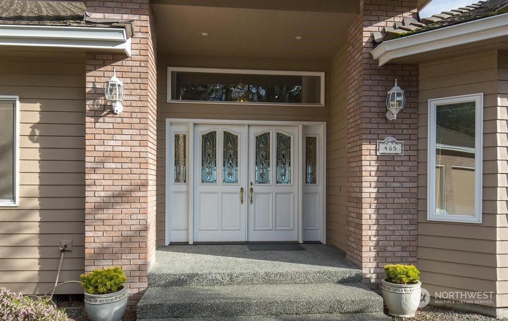 485 Doe Run Road Sequim, WA 98382 - Photo 11 of 40 a front view of a house with potted plants