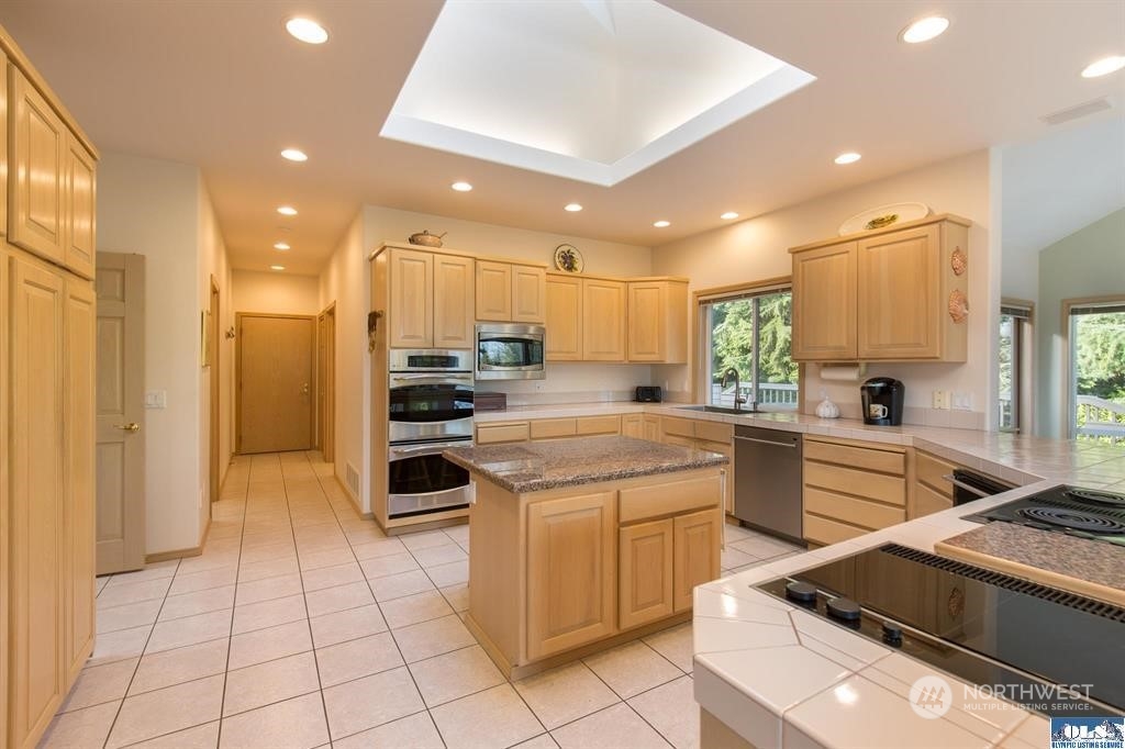 485 Doe Run Road Sequim, WA 98382 - Photo 18 of 40 a kitchen with a sink stainless steel appliances and cabinets