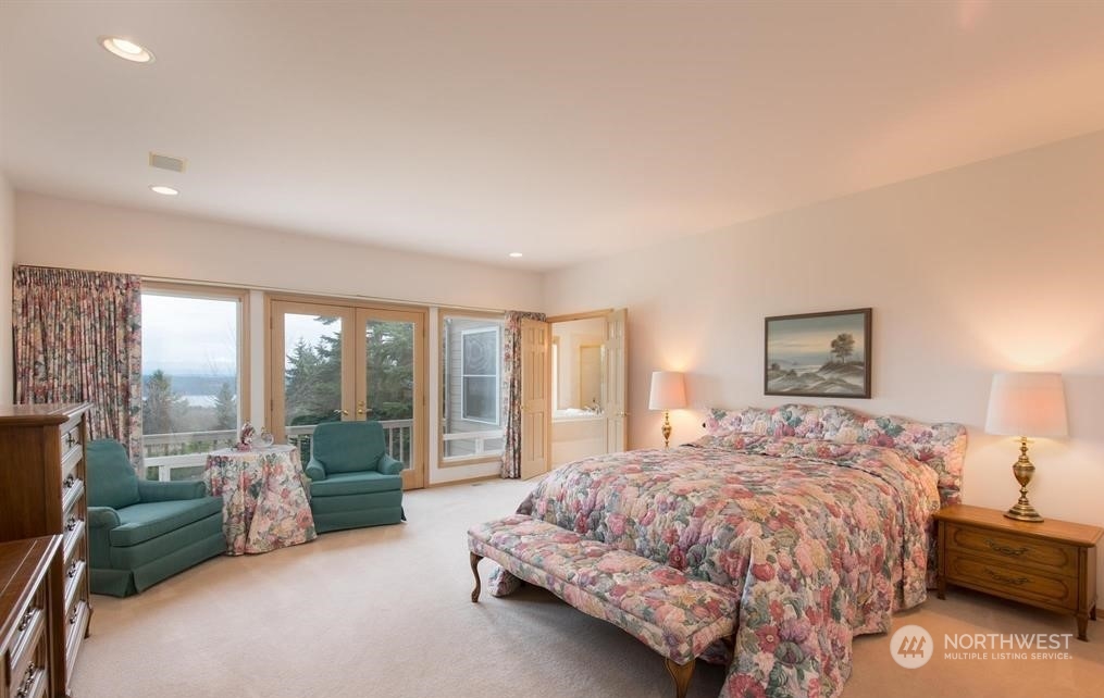 485 Doe Run Road Sequim, WA 98382 - Photo 25 of 40 a spacious bedroom with a bed and large windows