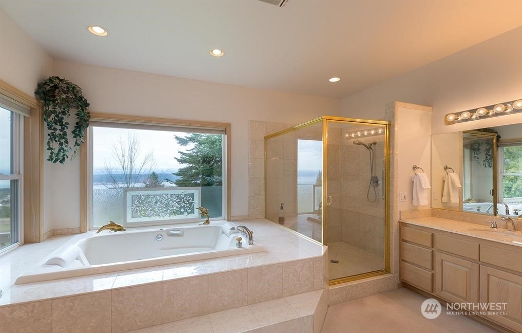485 Doe Run Road Sequim, WA 98382 - Photo 29 of 40 a spacious bathroom with a tub sink shower and mirror