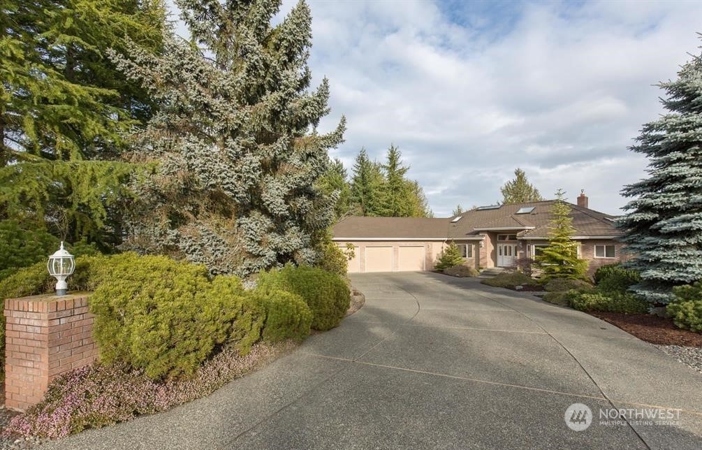 485 Doe Run Road Sequim, WA 98382 - Photo 3 of 40 a front view of a house with a yard and garage