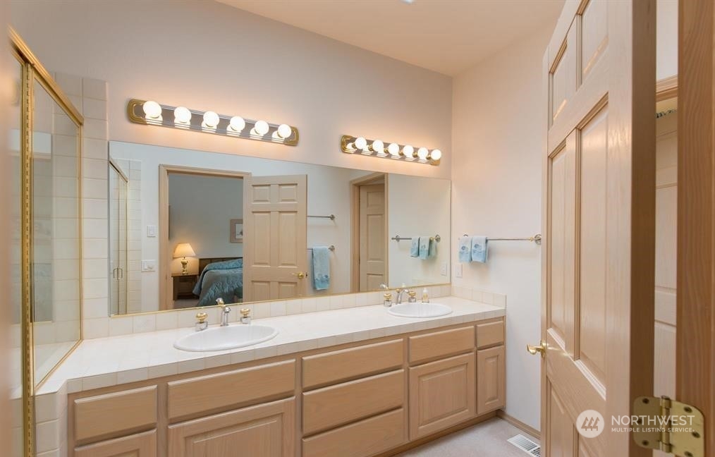 485 Doe Run Road Sequim, WA 98382 - Photo 38 of 40 a bathroom with a double vanity sink and a mirror