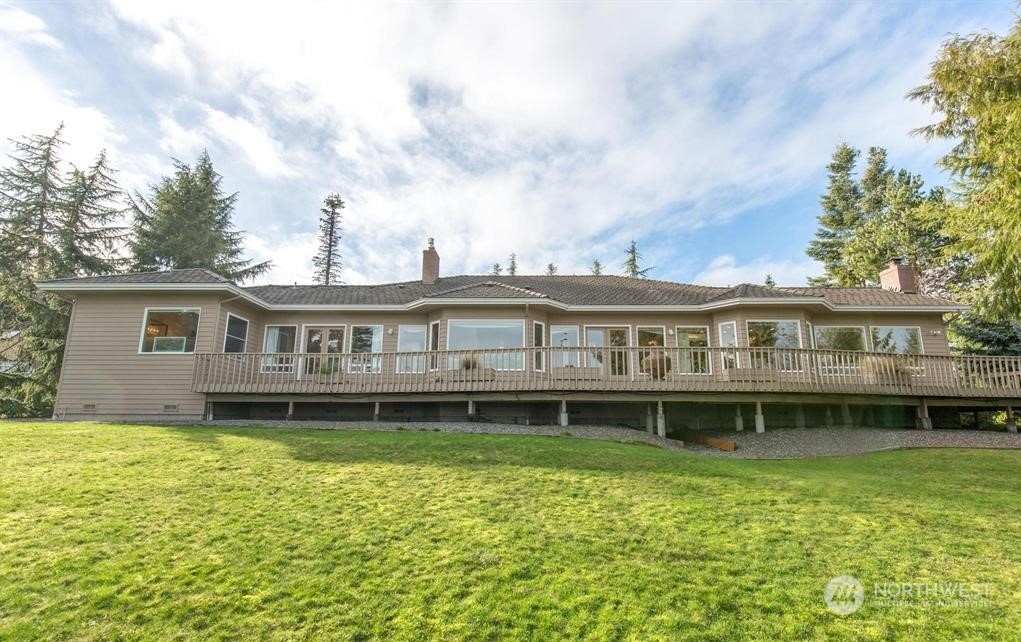 485 Doe Run Road Sequim, WA 98382 - Photo 9 of 40 a front view of a house with a garden and deck
