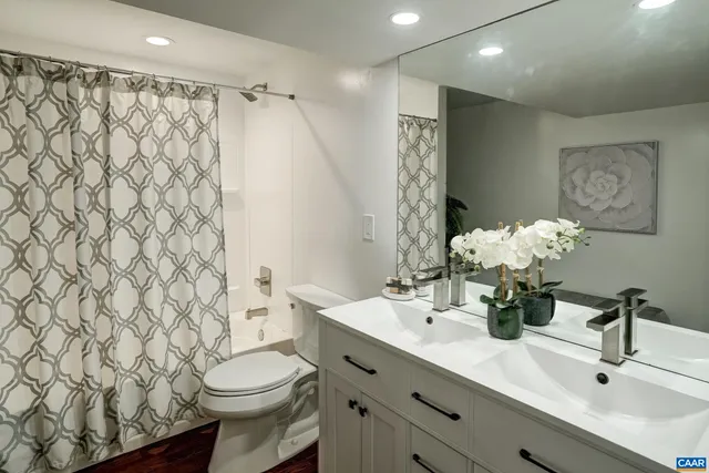 a bathroom with a double vanity sink toilet and a mirror