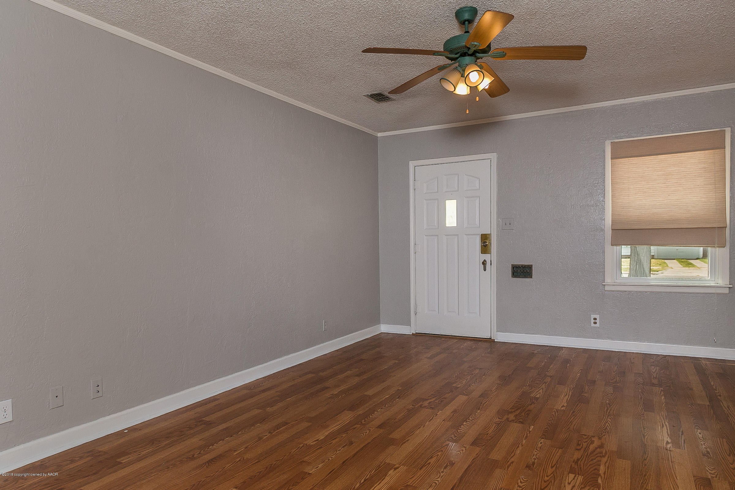 917 South Rusk Street Amarillo, TX 79102 - Photo 3 of 13 a view of an empty room with window and wooden floor