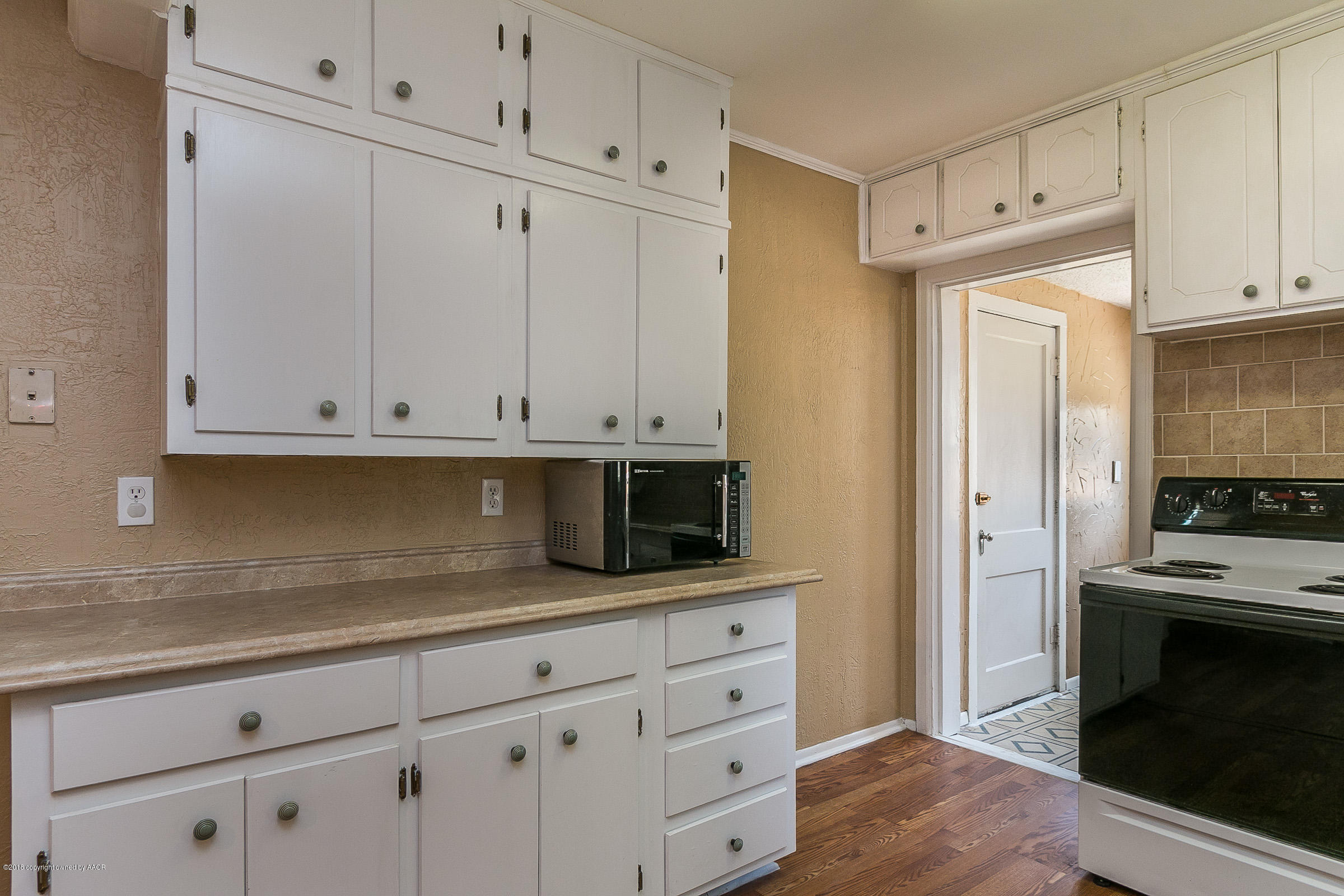 917 South Rusk Street Amarillo, TX 79102 - Photo 6 of 13 a kitchen with granite countertop white cabinets and stainless steel appliances