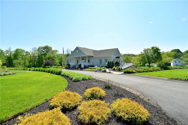 a view of an house with a yard and sitting area