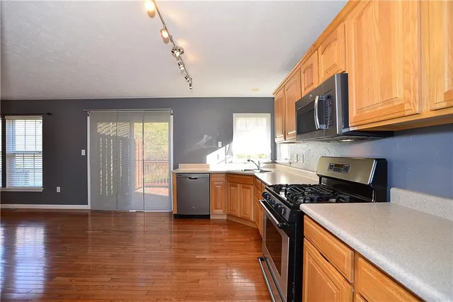 a kitchen with stainless steel appliances a stove a sink and a microwave