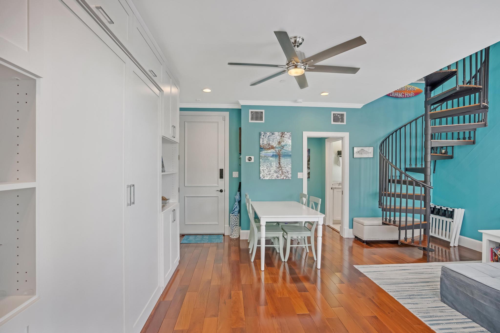 616 Caroline Street, Unit 5 Key West, FL 33040 - Photo 20 of 41 a dining room with wooden floor a chandelier fan a wooden floor and a ceiling fan