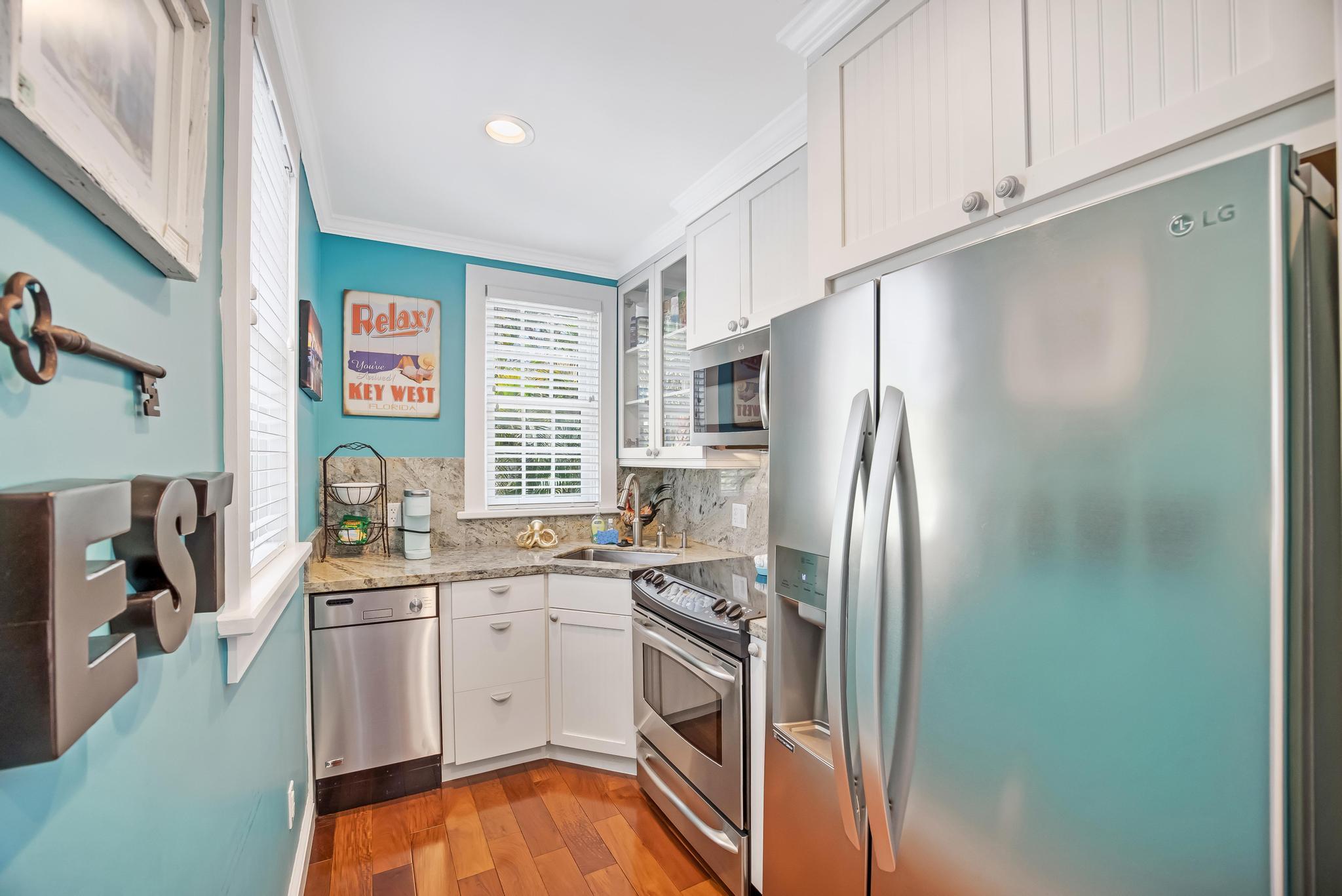 616 Caroline Street, Unit 5 Key West, FL 33040 - Photo 10 of 41 a kitchen with stainless steel appliances a refrigerator sink and cabinets