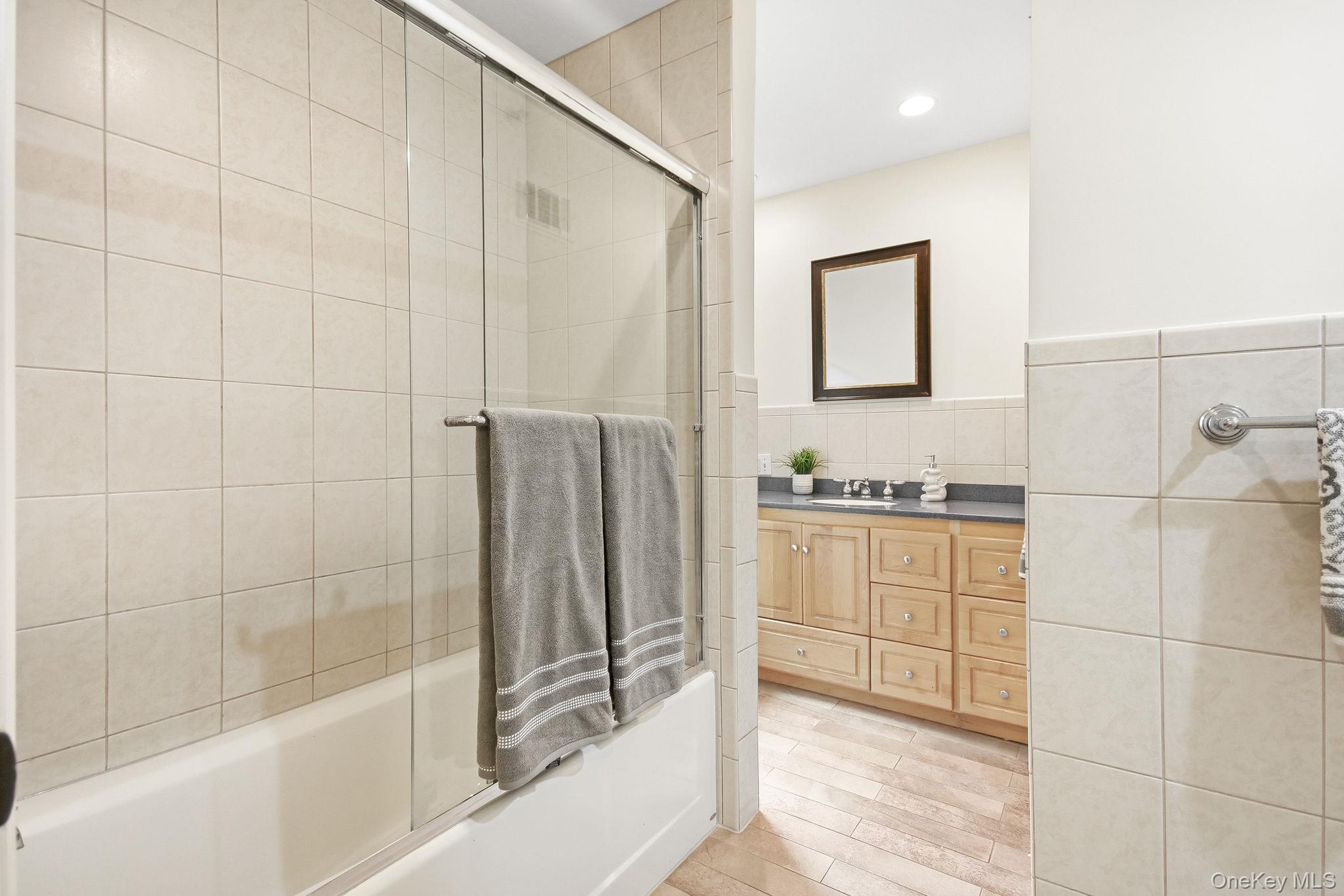 26 Century Ridge Road Purchase, NY 10577 - Photo 22 of 50 Second en-suite full bathroom; tiled bathtub with glass sliding doors, vanity and window