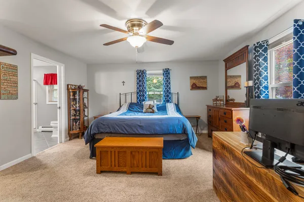 a spacious bedroom with a bed and a flat screen tv