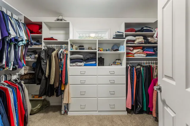 a view of walk in closet with clothes