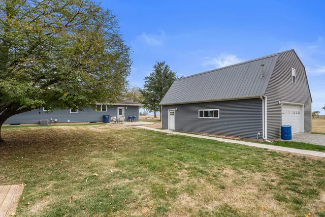 a front view of house with yard and trees in the background