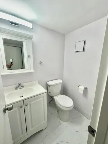 a bathroom with a toilet sink and mirror