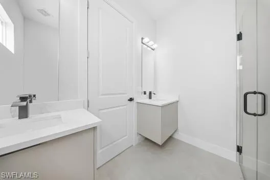 a bathroom with a double vanity sink a mirror and shower