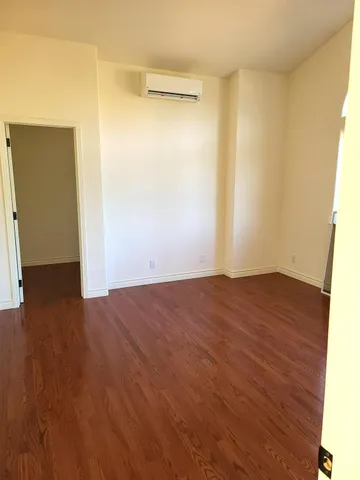 a view of empty room with wooden floor