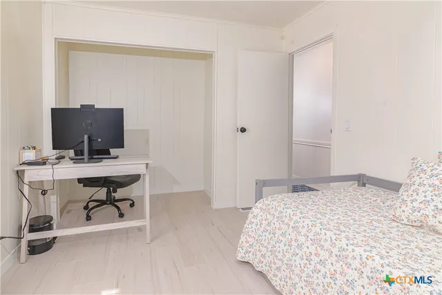 a bedroom with a large bed chandelier and a window
