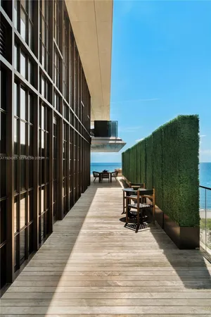 a view of a balcony with chairs and floor to ceiling window