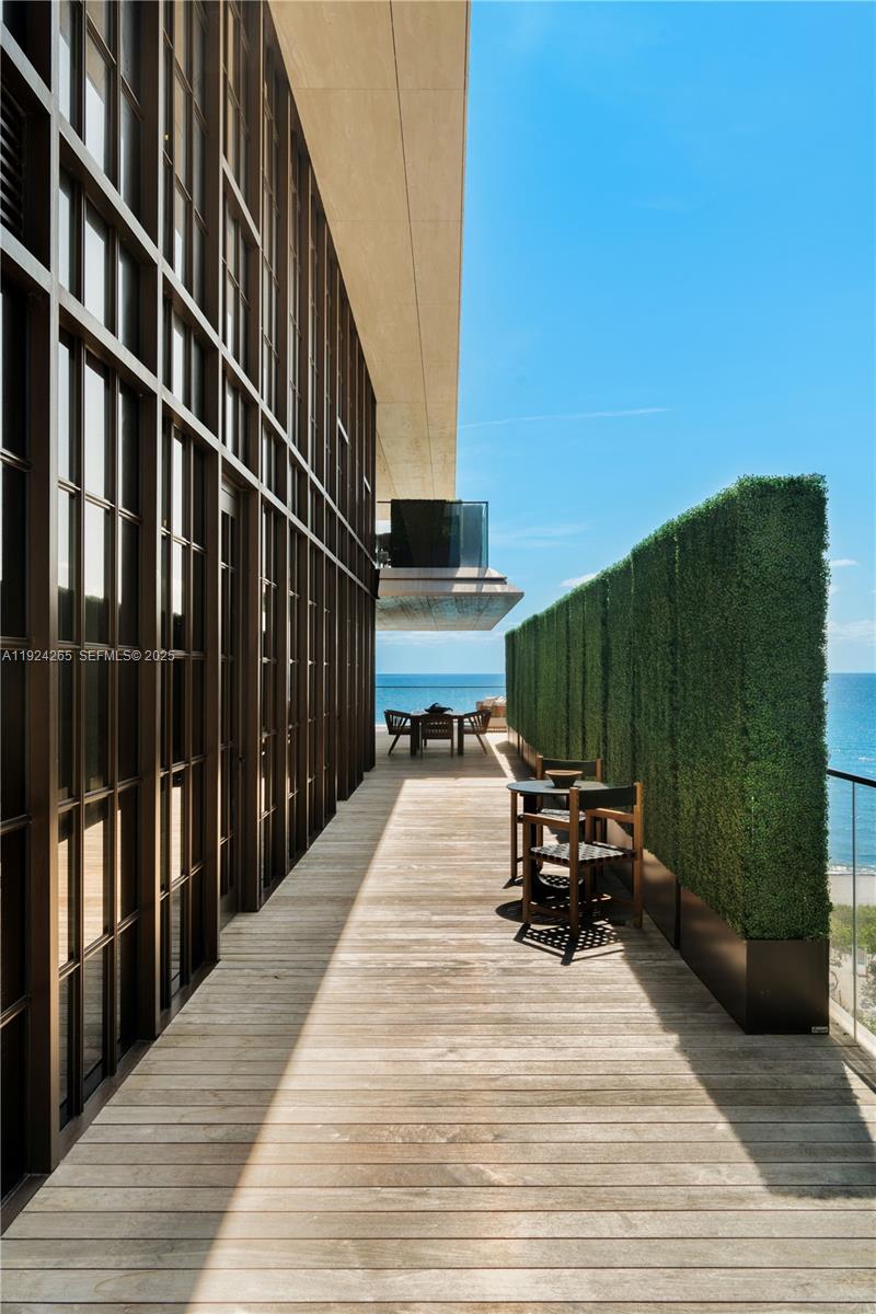 8955 Collins Avenue, Unit 702 Surfside, FL 33154 - Photo 41 of 56 a view of a balcony with wooden floor and a potted plant