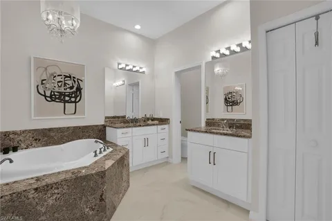 a spacious bathroom with a granite countertop sink a mirror a shower and a bathtub