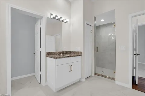a bathroom with a granite countertop sink a shower and a mirror