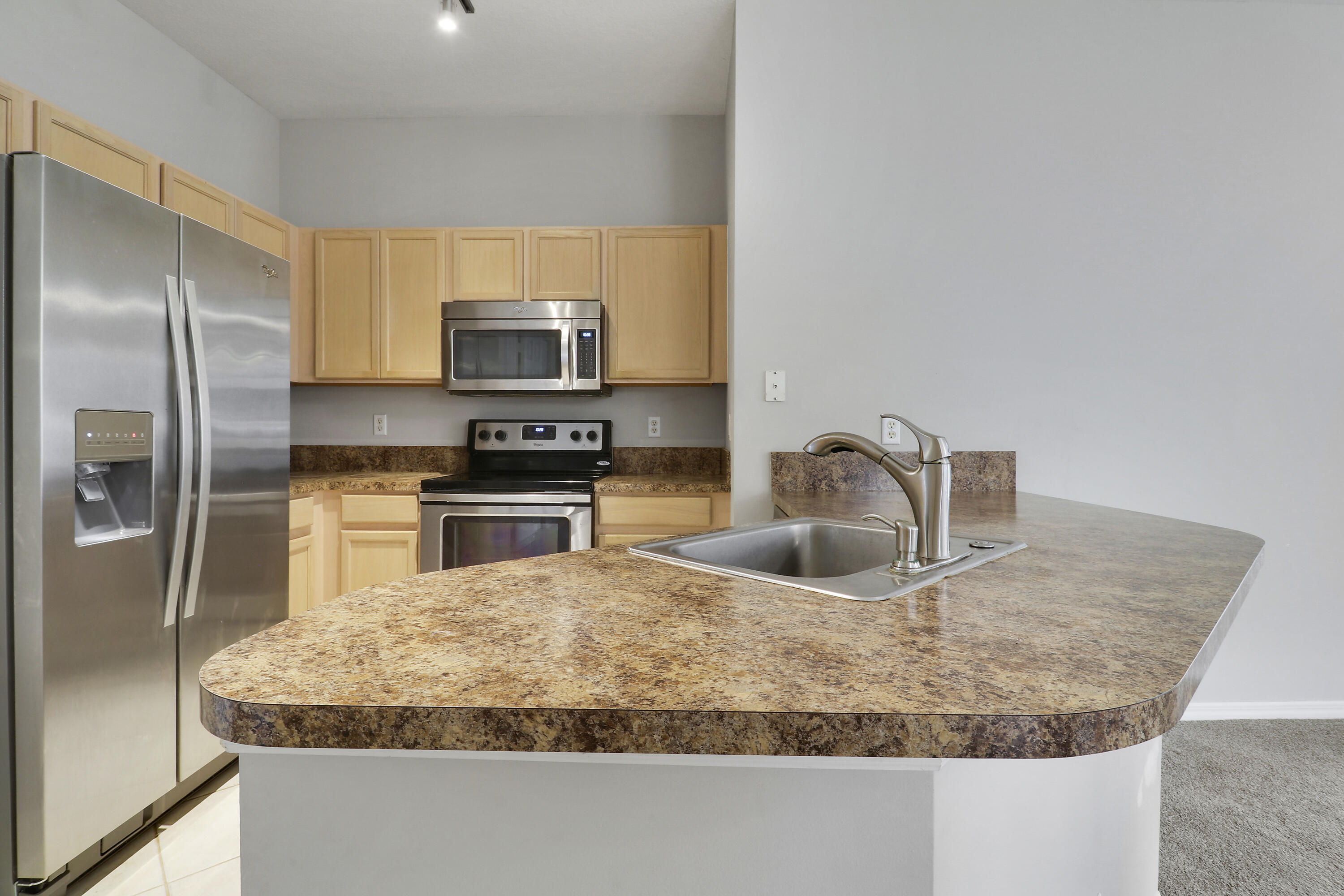 104 Lighthouse Circle, Unit H2 Tequesta, FL 33469 - Photo 14 of 45 a kitchen with kitchen island a sink stove and refrigerator