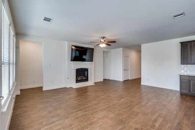 a view of an empty room with fire place and a window