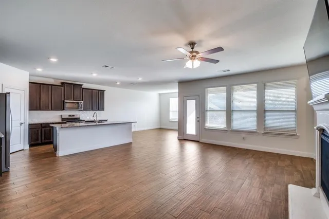 a view of kitchen with refrigerator stove and wooden floor
