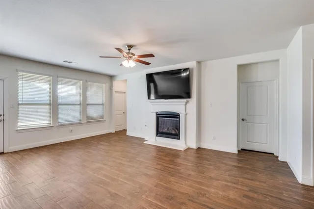 a view of a livingroom with a flat screen tv a ceiling fan and window
