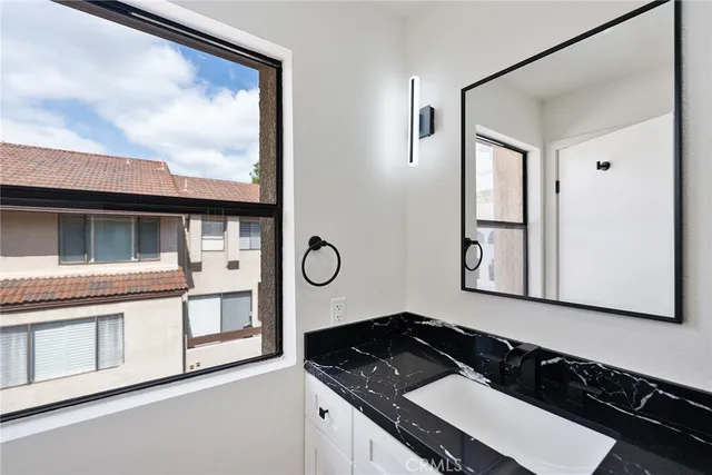 a bathroom with a granite countertop sink and a mirror
