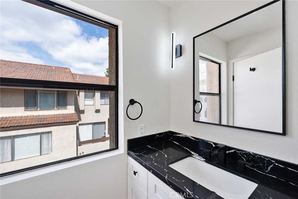 7 Wilderness Place Phillips Ranch, CA 91766 - Photo 12 of 25 a bathroom with a granite countertop sink and a mirror