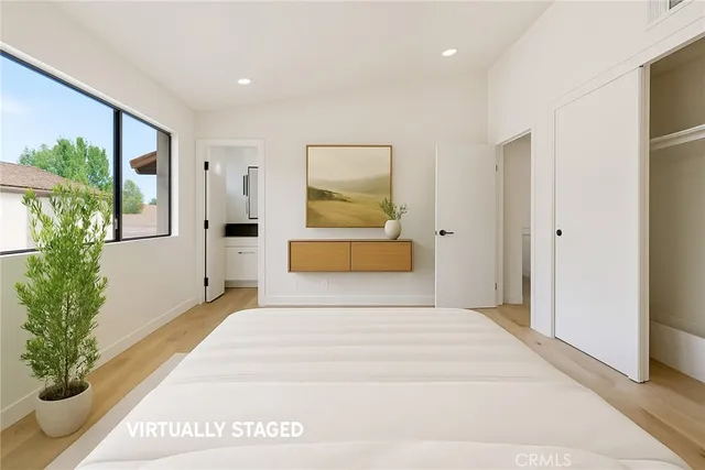 a bedroom with a large bed and a potted plant