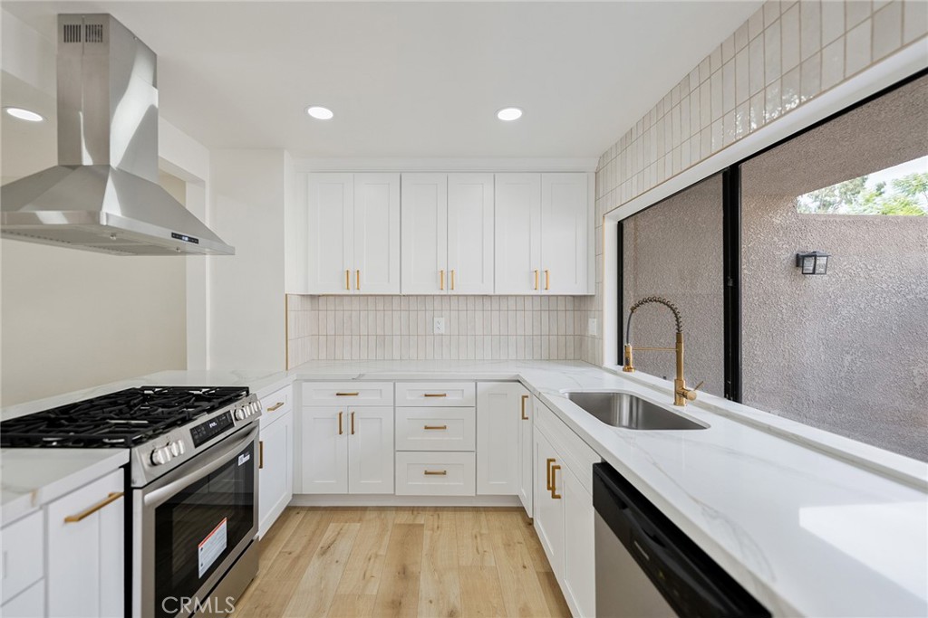7 Wilderness Place Phillips Ranch, CA 91766 - Photo 7 of 25 a kitchen with a sink stove and cabinets